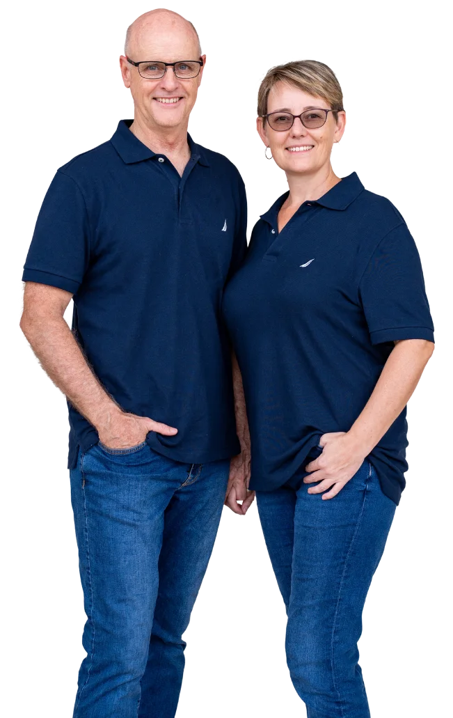 Smiling couple standing together in matching blue polos and jeans, representing trusted cash home buyers in Monroe County, Indiana